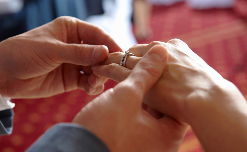 Joined hands with wedding rings